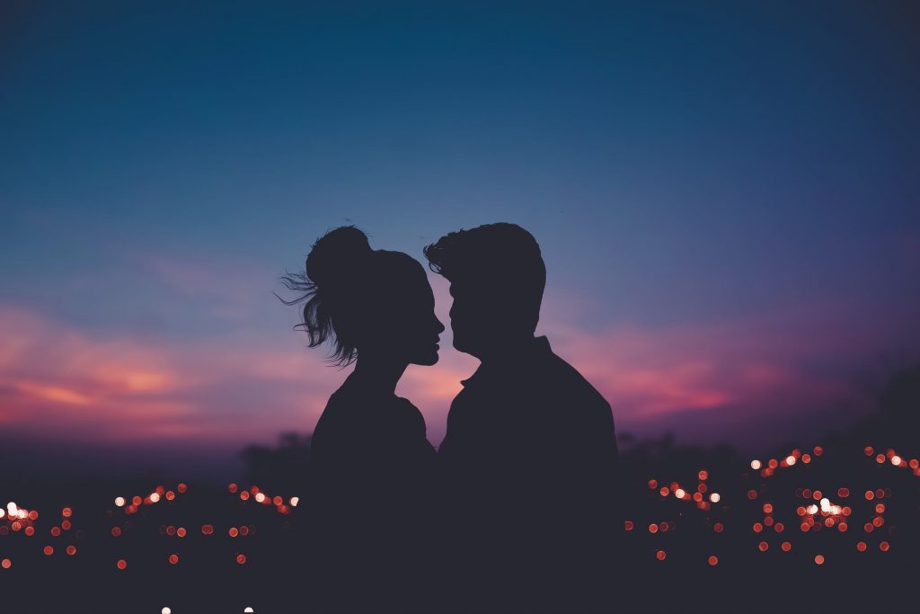Couple d'amoureux qui admirent une ville de nuit pendant un voyage